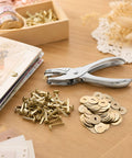 All In One Paper Fastener Kit With Hole Punch Tool And Golden Brads For Crafts, Scrapbooking, And Card Making, 100 Pcs Metal Fasteners, Smooth Paper Piercing, Easy Setup on wooden desk