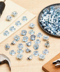 Four Prong Tee Nuts 400 Pack Three Eigh In One Six Thread Galvanized Steel Barrel Nuts Heavy Duty Hardware For Woodworking And Cabinet Builds laid out on a wooden table with tools.