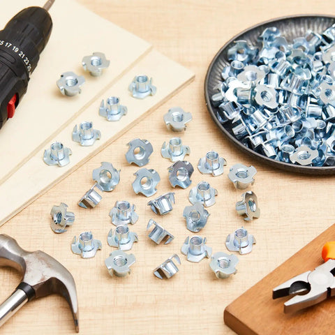 Four Prong Tee Nuts 400 Pack Three Eigh In One Six Thread Galvanized Steel Barrel Nuts Heavy Duty Hardware For Woodworking And Cabinet Builds laid out on a wooden table with tools.