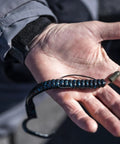 Hand holding Plum Power Worm Soft Plastic Fishing Bait With Irresistible PowerBait Formula And Classic Curly Tail Profile, 10 Inch