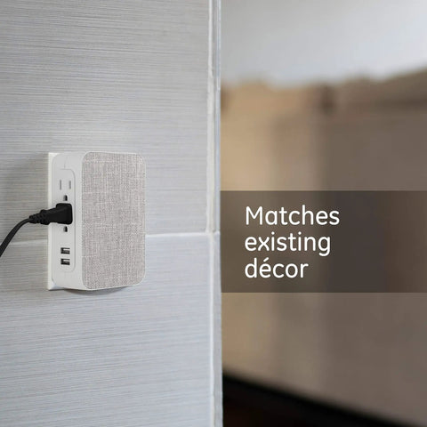 Five Outlet Extender With USB Ports Twin Pack Surge Protector 560 Joules Side Access Fabric Wall Tap Adapter plugged in and blending with decor.