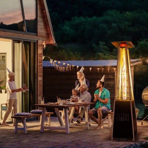 Backyard Hangout Ready 48,000 BTU Pyramid Flame Patio Heater with glass tube beside family on patio at night
