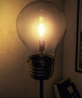 Close-up of vintage LED Edison bulb in glass shade of Edison Floor Lamp In Antique Brass Finish, Rustic Vibe, 71.5 Inch Tall
