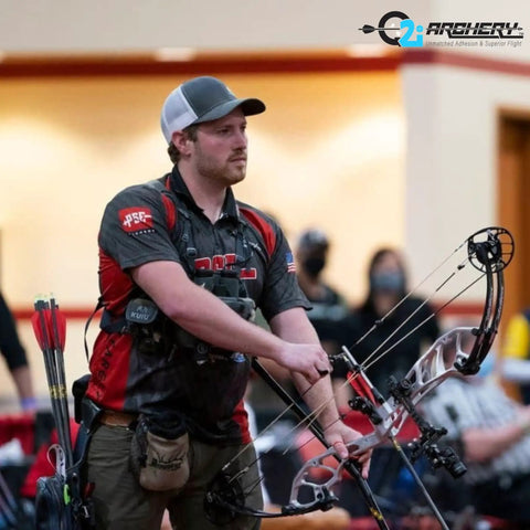 Archer preparing to shoot an arrow with compound bow, using Fusion-II 2.1 Inch Pink Arrow Fletching Vanes, 36 Pack, in competition.