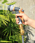 Brass Garden Hose Quick Connect Set With Shutoff Valve in use, connected to a nozzle watering plants, three quarter inch fittings