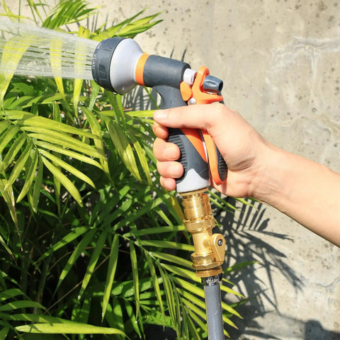 Brass Garden Hose Quick Connect Set With Shutoff Valve in use, connected to a nozzle watering plants, three quarter inch fittings