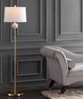 60 Inch Dope Brass Gold And White Modern Floor Lamp With White Linen Drum Shade next to a grey sofa, UL Listed, LED Bulbs Included