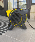Heavy Duty Utility Blower With 3 Speed Portable Floor Fan on entrance floor, showcasing pivoting head and rugged construction.
