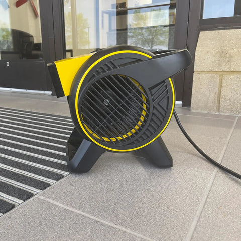 Heavy Duty Utility Blower With 3 Speed Portable Floor Fan on entrance floor, showcasing pivoting head and rugged construction.