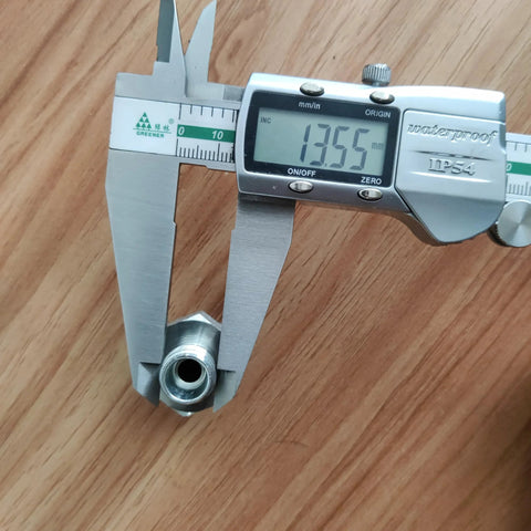 Two silver hydraulic hose fitting adapters (14H to 18ED) held in calipers.