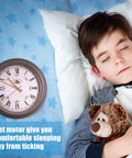 Child sleeping next to a wall clock with a message about a quiet motor that provides a comfortable sleeping environment.