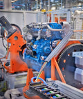 Engine assembly line in factory with machinery and components in focus
