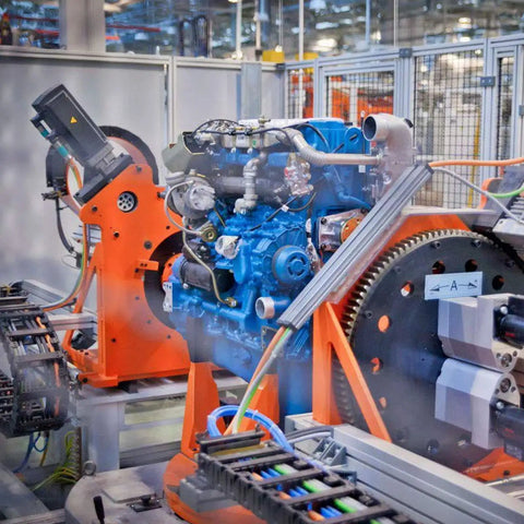 Engine assembly line in factory with machinery and components in focus