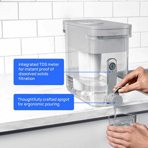 Person pouring water from ZeroWater Technology 23 Cup Water Filter Dispenser With 5 Stage Filtration Reducing Lead, PFAS, Mercury, Fluoride, and Chlorine, Certified Clean Water for Family, Kitchen On the Go, showing ergonomic spigot and TDS meter.
