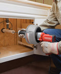K-45AF Air Powered Drain Cleaner 230V Drum Auger for Swage Lines and Sewer Pipes in use under a sink.
