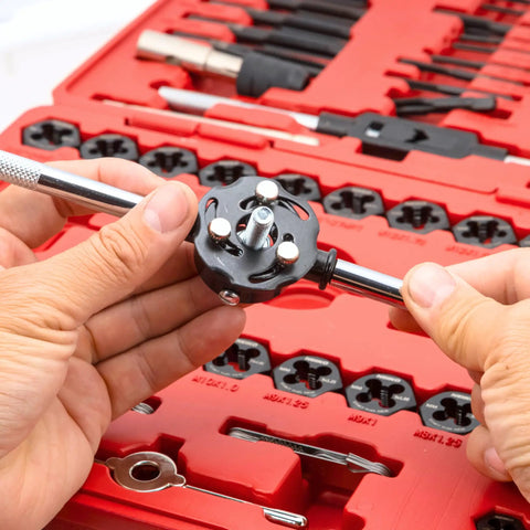 Hands holding die handle in 76 Piece Tap And Die Set For External And Internal Threads Rethreading Cutting And Repair Tool Kit