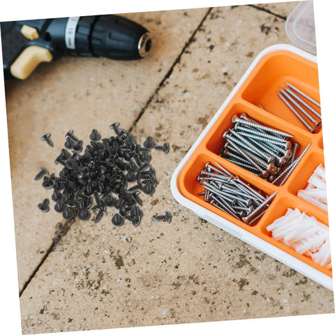 Genuine M4x10mm Carbon Steel Mini Screws With Slick Black Finish scattered on a work surface, ideal for DIY projects.
