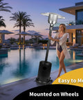 Woman beside 50,000 BTU Outdoor Propane Patio Heater with Wheels, Durable Powder Coated Steel near pool at sunset.