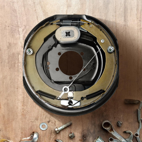 Electric trailer brake assembly backing plate inner view; 12x2 in, metal brake shoes and springs.