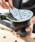 Person attaching ETS 150 Soft Sanding Pad For Heavy Duty Universal Use With High Temperature Durability StickFix Quick Change