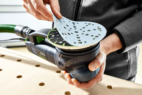 Person attaching ETS 150 Soft Sanding Pad For Heavy Duty Universal Use With High Temperature Durability StickFix Quick Change