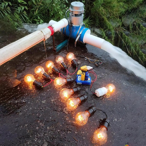 1000W Portable Water Turbine Generator 220V Micro Hydroelectric Power System With Aluminum Alloy Shell in outdoor setup powering light bulbs
