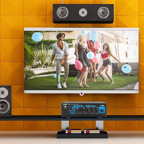 Living room setup with 2x120W Home Audio Power Amplifier System With Dual Channel Mixer, Stereo Receiver Box, and speakers on shelf.