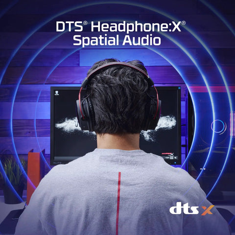 Person wearing Cloud Alpha Wireless Gaming Headset for PC with DTS Headphone X audio in front of gaming setup.