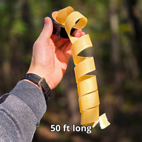 Person holding Fire Strip Roll 50-Foot Weatherproof Waxed Fire Starter Tinder Tape in hand outdoors.