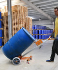 Badass 55 Gallon Drum Dolly Heavy Duty Drum Truck With Reinforced Steel Frame 1000 Lb Capacity maneuvering a blue barrel in a warehouse.