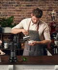 Barista pouring coffee with an Electric Moka Pot 6 Cup Coffee Maker for quick espresso Italian style on counter