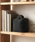 Heavy Duty Weighted Door Stopper With 4.4 Lb Internal Weight 6.3 Inch Square Base on a wooden shelf near books