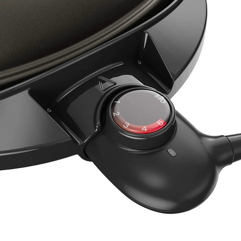 Close-up of the Go To Indoor Outdoor Electric Patio Grill With Removable Stand heat settings dial on black nonstick surface