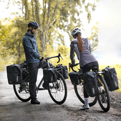 Cyclists using Waterproof Bike Pannier Bag 25L With Quick Release TPU Coating And Reflective Design for touring and commuting.