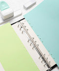 Go To 3 Hole Punch And 12 Piece Metal Ring Binder Set For A5 To A8 Notebooks in green featuring binder open with pastel pages