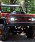 Front view of a red vehicle with off-road tires, showcasing a 1 1/8 Inch D Ring Shackle 9 Point 5 Ton Rated Heavy Duty Screw Pin Anchor Rigging Hardware.