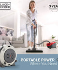Retractable 20 Foot Extension Cord Reel With Four Outlets Heavy Duty 16 AWG SJT Cable in living room with vacuum cleaner