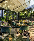 Outdoor restaurant setting with 2 Pack Cordless Rechargeable LED Table Lamps With 5000mAh Battery on tables, surrounded by greenery.
