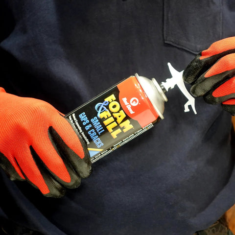 Heavy Lifters Expanding Spray Foam Sealant Fills Gaps And Cracks Straight Up, 12 Oz tube held by gloved hand.
