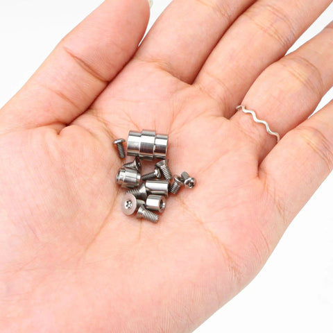 Heavy Duty Titanium Screw Pivot Upgrade Kit With Lanyard Tube Standoff Spacer And Blade Stop Hardware in hand showing various screws.