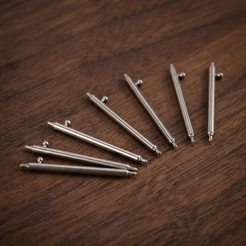 Stainless Steel Watch Band Pin Replacement Kit With Quick Release Spring Bars scattered on wooden surface