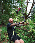 Person using All In One Zip Line Trolley Pro X With Brake Bundle in forest setting, showing harness and cable connection.