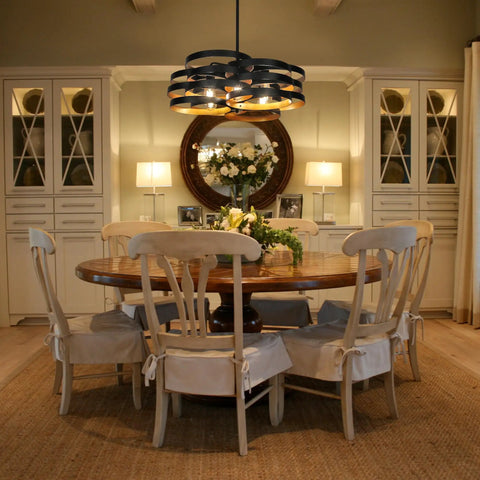 Dining room with Six Light Modern Farmhouse Chandelier With Stacked Ring Design In Black Metal And Gold Interior.