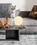 Mid Century Modern Brass Table Lamp With Gold Glass Globe on modern living room coffee table next to decor items