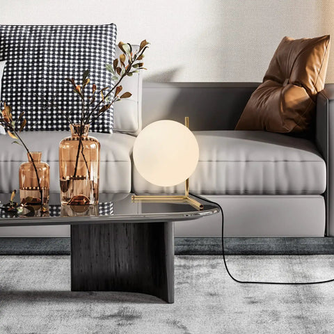 Mid Century Modern Brass Table Lamp With Gold Glass Globe on modern living room coffee table next to decor items