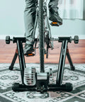 Cyclist using Portable Foldable Fluid Bike Trainer Stand For Indoor Riding With Stainless Steel Frame Near Silent Flywheel