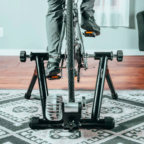 Cyclist using Portable Foldable Fluid Bike Trainer Stand For Indoor Riding With Stainless Steel Frame Near Silent Flywheel