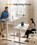 Two people using Electric Standing Desk With Three Memory Presets, 40 By 24 Inch Sit To Stand Desk, white frame in home office