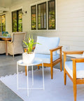 Outdoor patio with white wall seating area, weatherproof furniture, and view of a porch. Built Tough Heavy Duty 1-Gang Recessed Weatherproof In-Use Outlet Cover 6-In-1 Nonmetallic Design Horizontal Or Vertical Mount White Recessed Enclosure For Indoor Or Outdoor Outlets not shown.