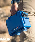 Freakishly Durable IP67 Waterproof Hard Shell Case Built For Tough Travel Days in blue held by a person outdoors.